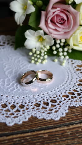 wedding rings and flowers on a lace doily