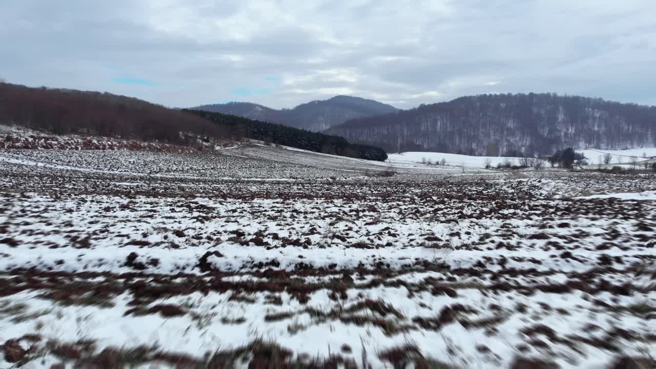 rápido aéreo sobre nieve cubierta de montaña campo llanuras día nublado de invierno