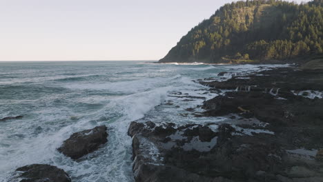 ocean waves crash onto rocks at captain cook point by thor's well in cape cove, oregon coast