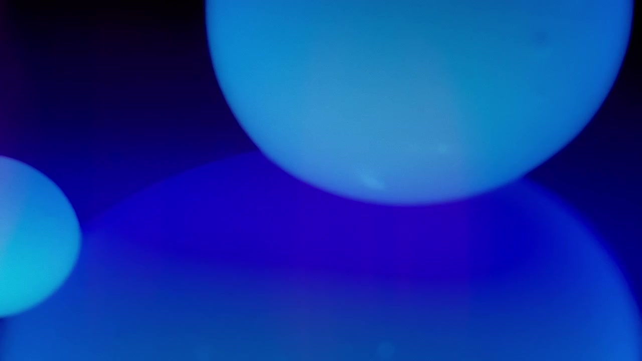 Bolle di lava blu che scorrono in un liquido su sfondo blu scuro