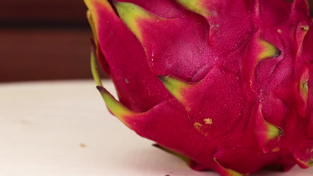 Detailed view of vibrant dragon fruit skin, highlighting its unique texture and colors.