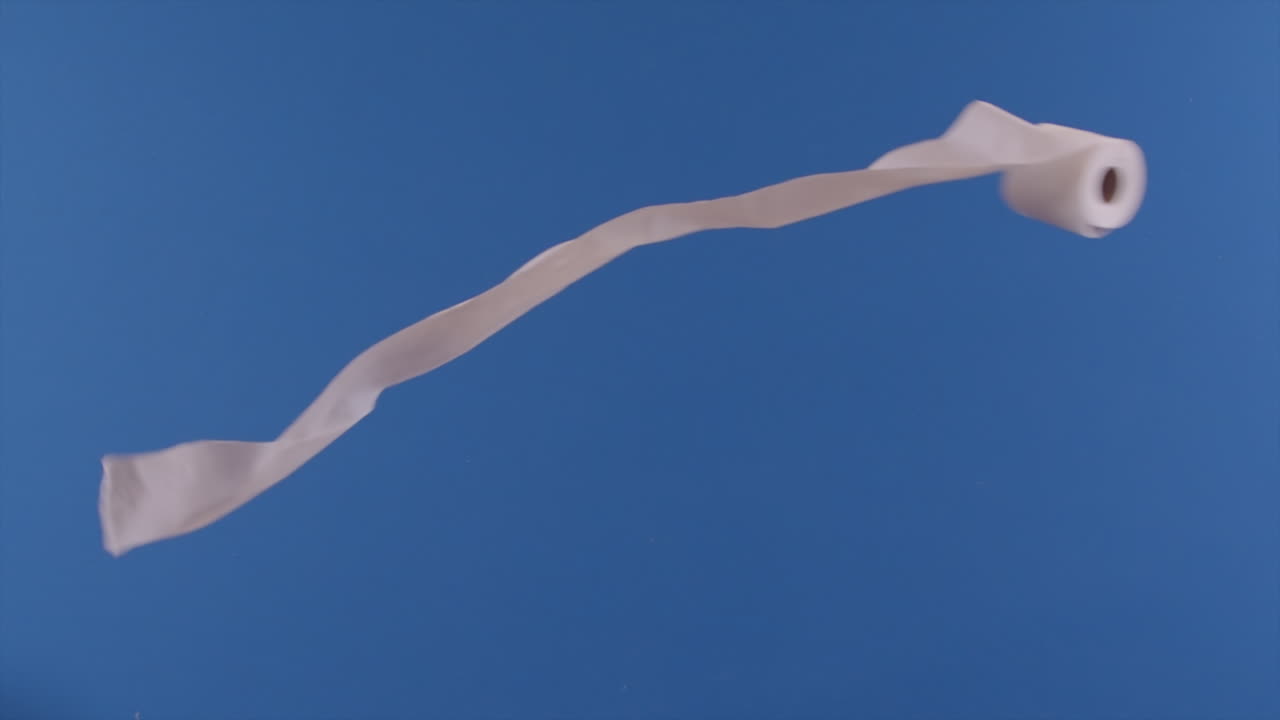 se ve un rollo de papel higiénico volando frente a una pantalla azul