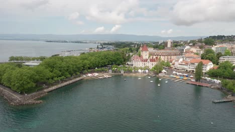 Drone-Volando-Sobre-El-Lago-De-Ginebra-Hasta-El-Café-Al-Aire-Libre-De-Chateau-D&#39;ouchy-En-Lausana,-Suiza