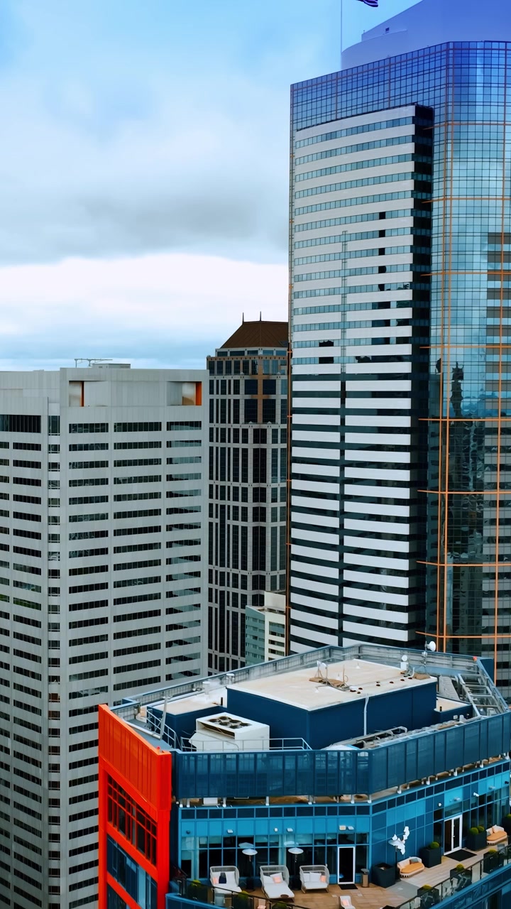 Elevando-se no topo dos edifícios mais altos no centro de Seattle, Estado de Washington, EUA. Centro financeiro de cidade moderna visto de cima. Vídeo vertical.