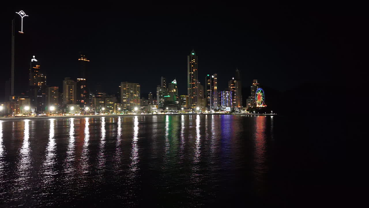 Balneario Camboriu skyline at night reflects on calm Brazilian waters