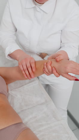 cosmetólogo masajista haciendo tratamiento de mujer masaje fregando la mano con fregado en la clínica de spa