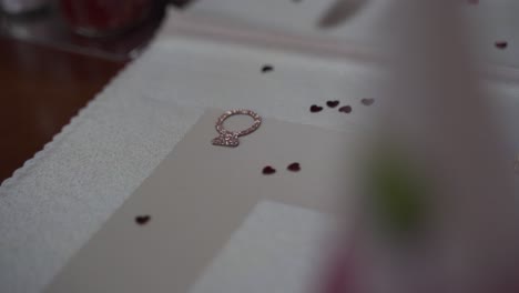 Decoration-confetti-for-a-wedding-on-a-table-with-small-hearts-and-rings