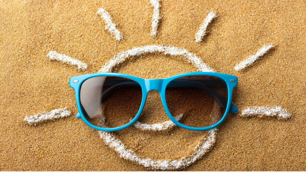 Bright sunglasses resting on sandy beach. Sunglasses sit on warm sand, creating a cheerful scene under the sun during a summer day
