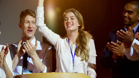 gente de negocios multiétnica feliz aplaudiendo a una joven empresaria en el escenario en el seminario 4k