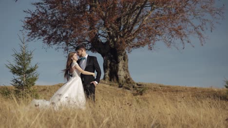 Recién-Casados.-Novio-Caucásico-Con-Novia-Cerca-De-Un-Hermoso-árbol-Otoñal.-Pareja-De-Novios