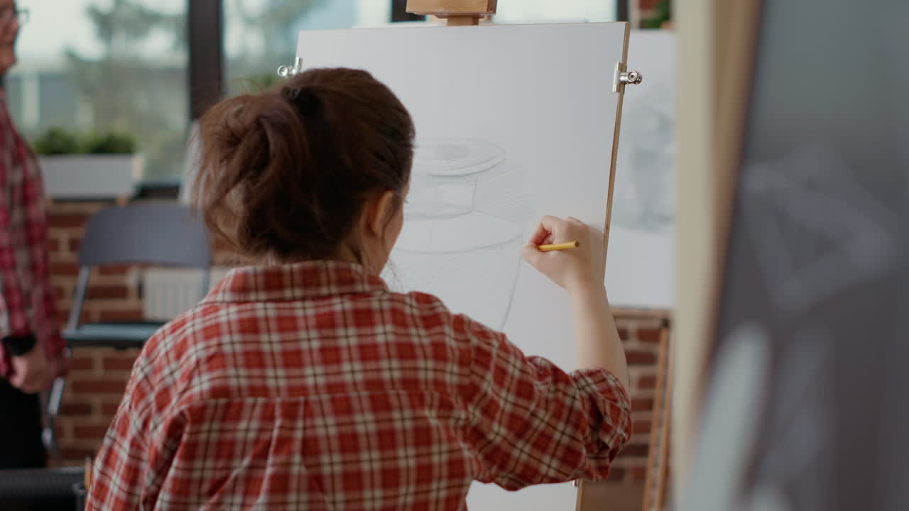 Young woman attending artistic workshop to draw vase model