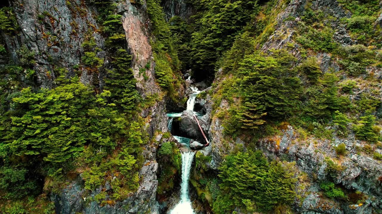 Riprese aeree con drone dalla Nuova Zelanda della Cascata Devil's Punchbowl, volando attraverso il ruscello.