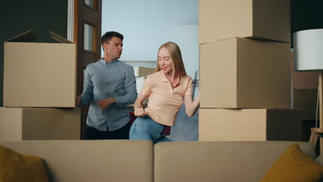 couple dancing new apartment between packed boxes. family moving in flat.