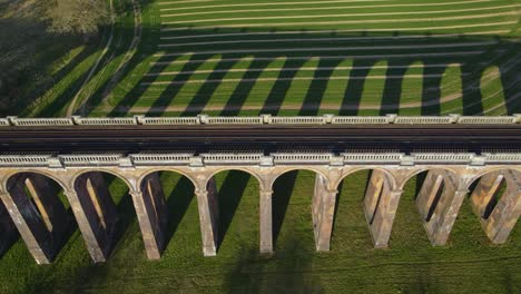 aerial sideways over railroad of ouse valley or balcombe viaduct, sussex in england, uk