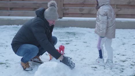 grandfather and granddaughter having fun in the snow