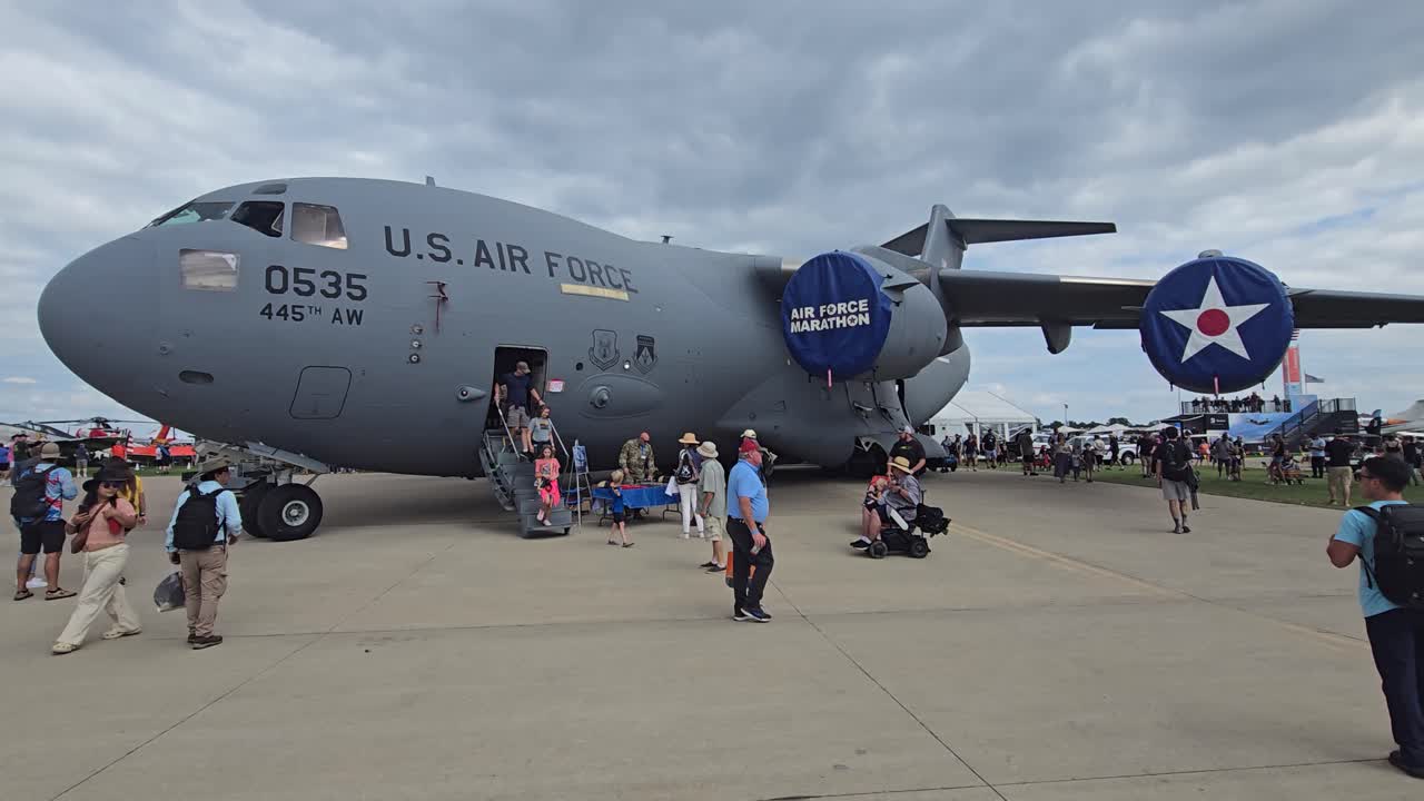 The U.S. Air Force C-17 Globemaster aircraft on display at an airshow, with attendees boarding and exploring the interior.