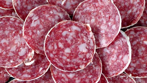 pieces of salami slowly rotate on table.