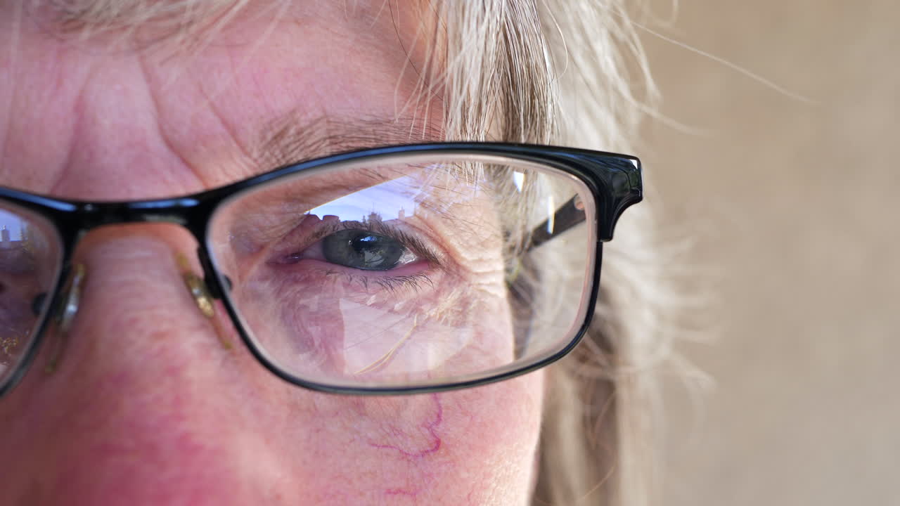 cierre el ojo de una anciana que se pone anteojos recetados después de hacerse un examen en el optometrista