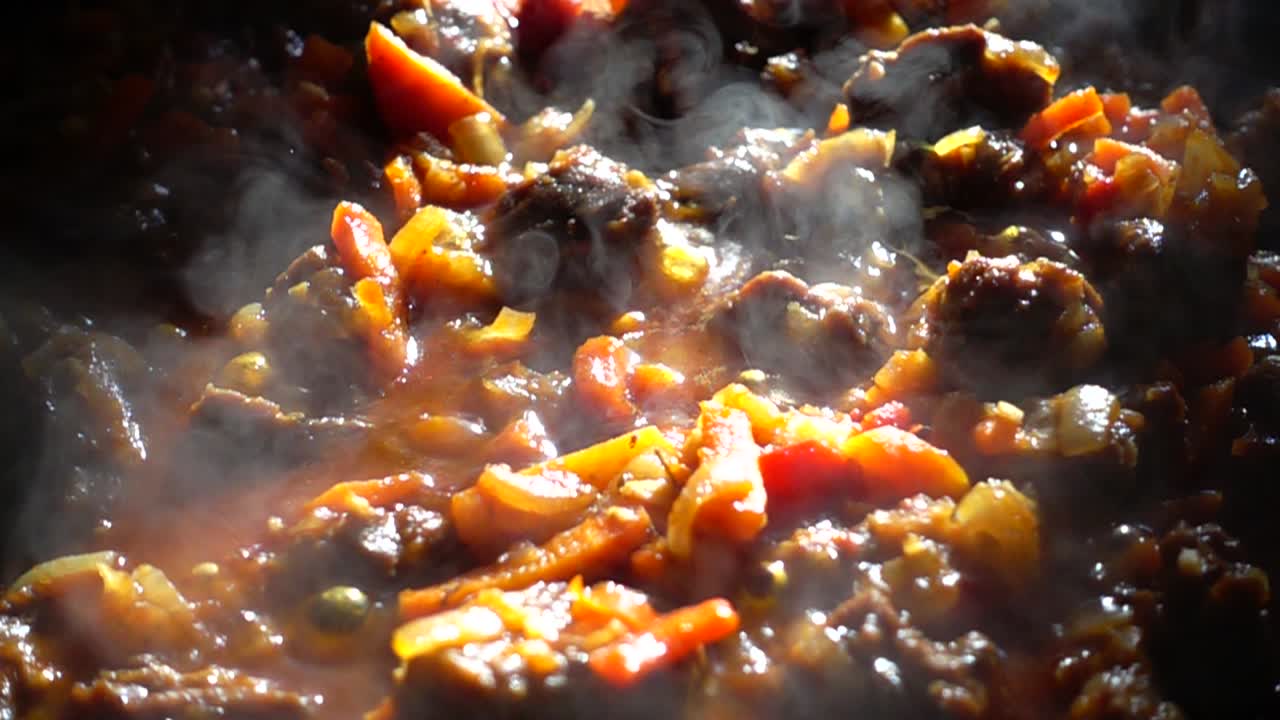 Proceso de preparación de gulash con verduras en una sartén de hierro fundido. Cámara lenta