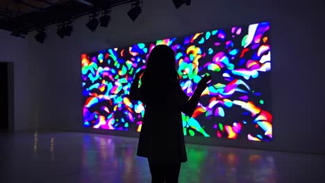 Woman Observing Colorful Digital Art Projection