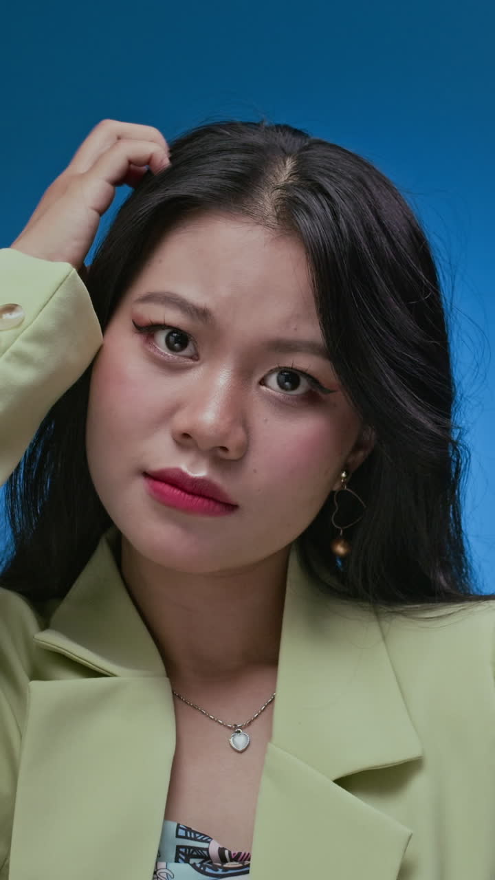 Young Brunette Expressing Surprise against Neon Blue Wall