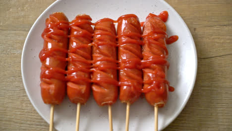 fried-sausage-skewer-with-ketchup-on-white-plate