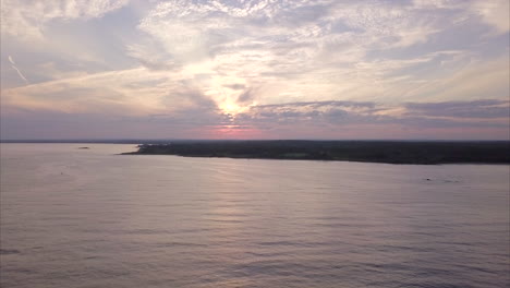 toma aérea volando sobre el vasto océano atlántico al atardecer frente a la playa de kettle cove, maine