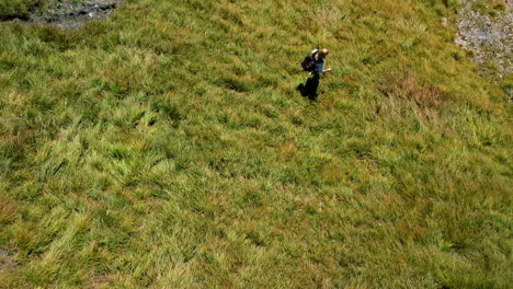 Aerial-shot-of-a-blonde-girl-hiking-in-the-swiss-alps