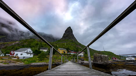 View-from-footbridge-of-clouds-around-imposing-mountain-peak,-Reine