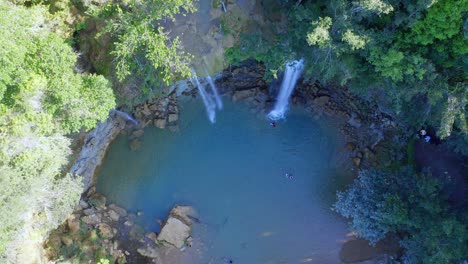 tourists swim at natural pool of salto alto with waterfalls in bayaguana, dominican republic