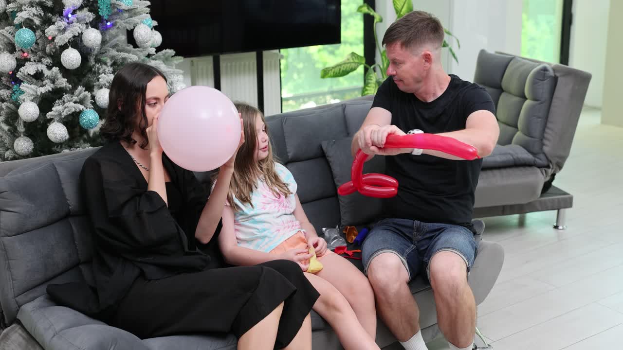 Famiglia che crea animali con i palloncini e gonfia palloncini a casa