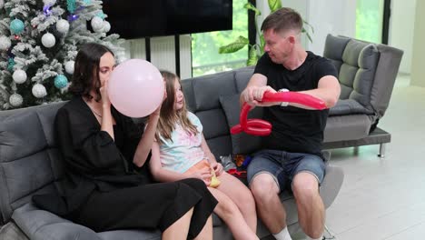 family making balloon animals and blowing balloons at home