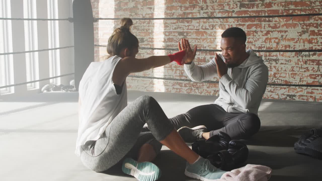 Video of happy fit diverse woman and man boxing at gym