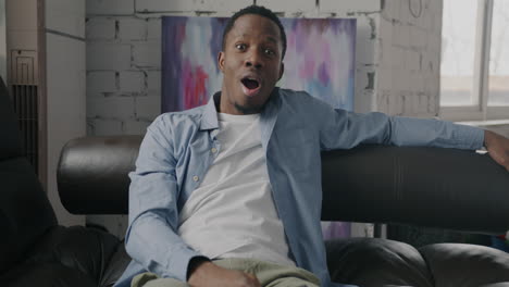 man relaxing and surprised on a couch