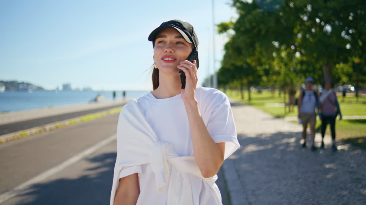 Walking girl talking smartphone enjoying summer day outdoors closeup
