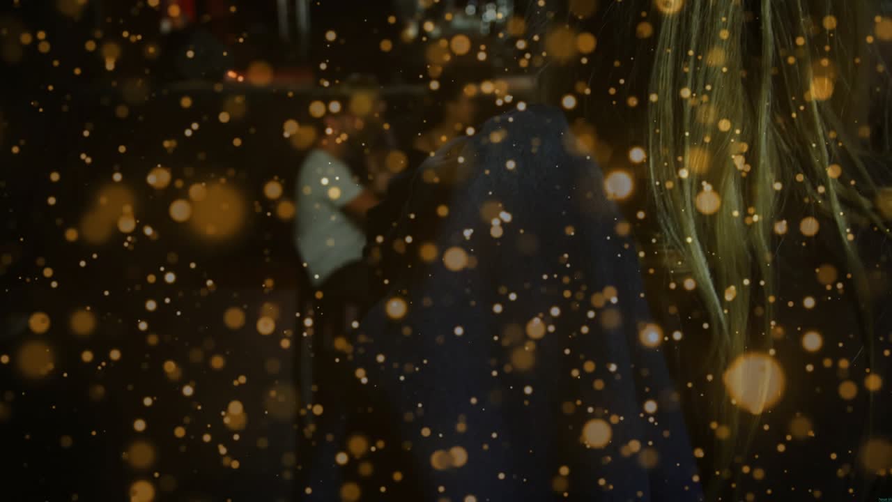Woman entering, leaning over table checking tray for order, man holding cup under golden bokeh bar