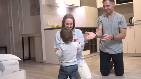 Boy-Playing-On-The-Floor-With-A-Toy-Truck,-Then-Gets-Up-And-Takes-His-First-Steps-Towards-The-Kitchen