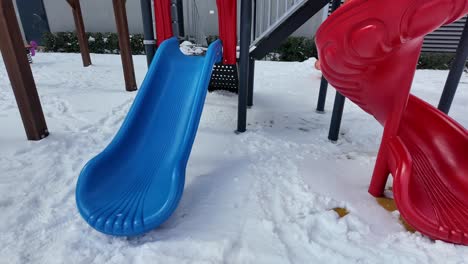 snowy playground with blue and red slides