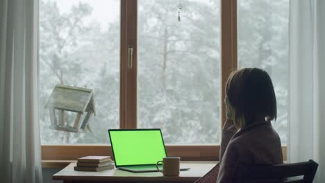 side portrait of young woman talking on cellphone sitting by window slow motion. happy girl holding smartphone while working at home indoors natural light shallow dof. communication technology