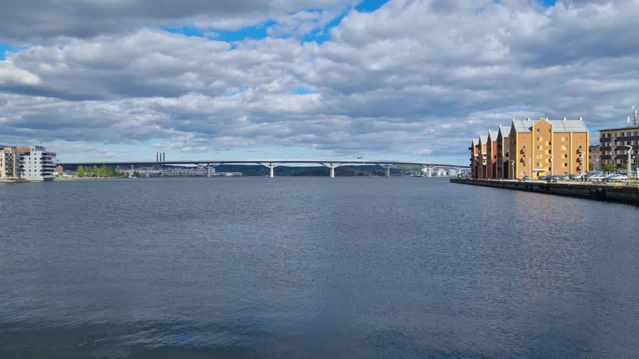 Scenic view of the Selångersån River delta in Sundsvall, Sweden, where it flows into Sundsvall Bay, with residential buildings along the water and Sundsvallsbron bridge in the distance