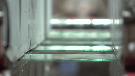 glass panels moving on conveyor inside the machine which smooths edges of the sheets