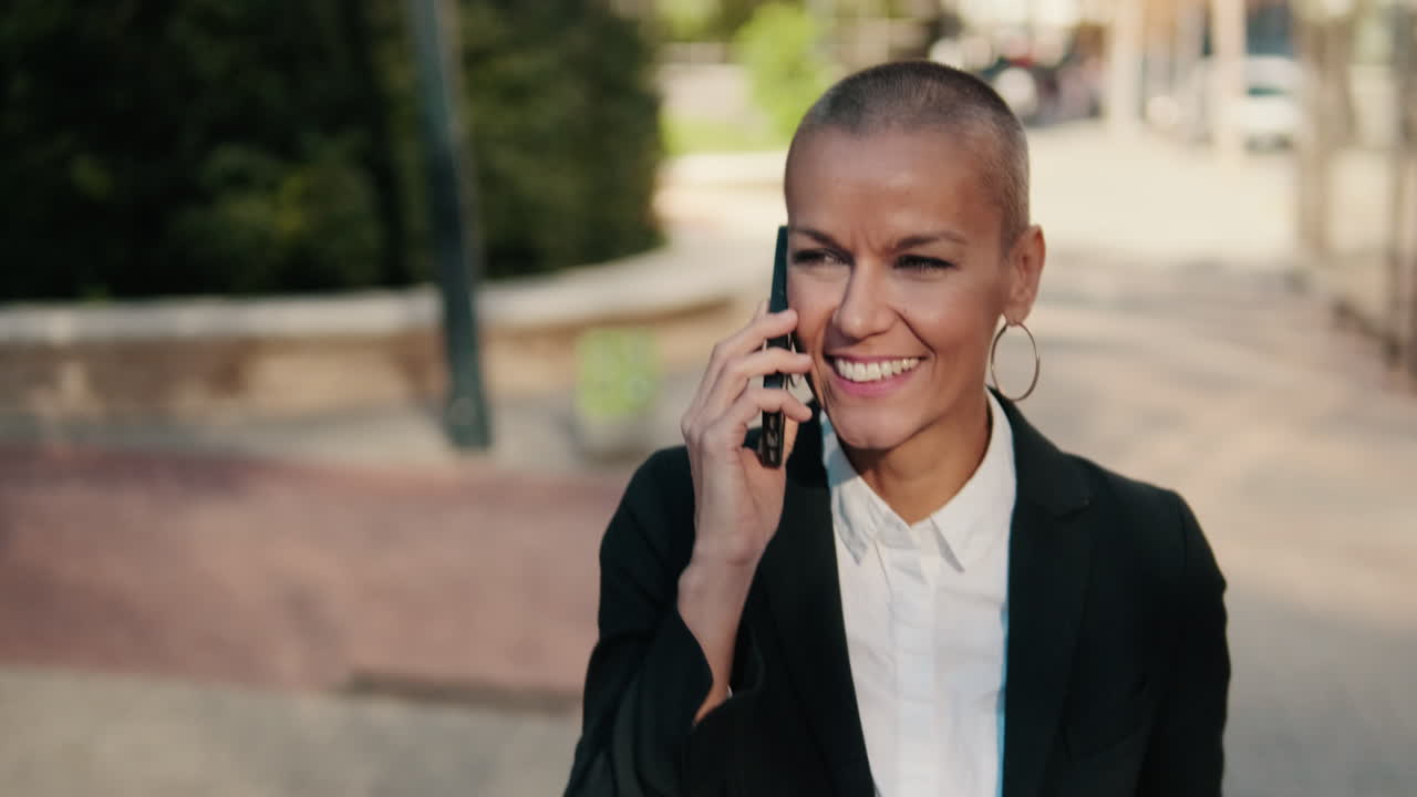 Donna d'affari felice che parla al cellulare all'aperto
