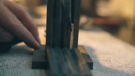 jeweler-opens-form-and-takes-off-gold-bar-on-table-closeup