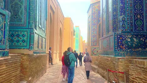 tourists exploring the vibrant tiled architecture of the shahi-zinda necropolis in samarkand, uzbekistan