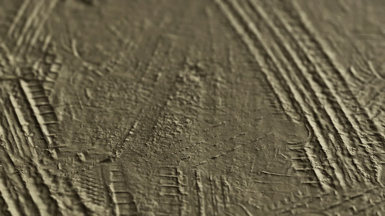 Patterns created by tire tracks on a textured surface during the afternoon