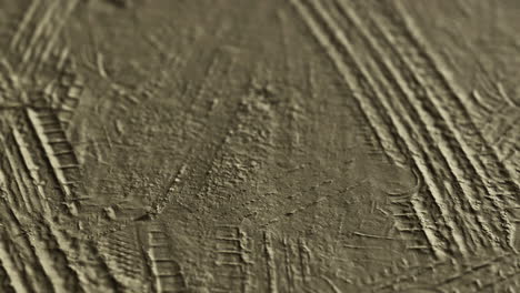 patterns created by tire tracks on a textured surface during the afternoon