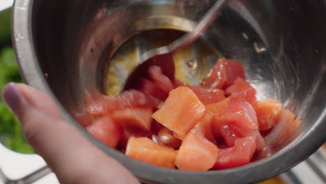 mixing diced and uncooked salmon and tuna fish with soy sauce