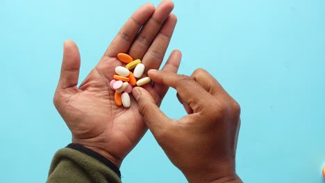 manos con varias pastillas de colores