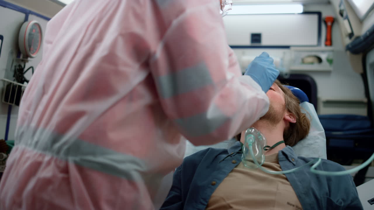 médicos de emergencia tomando un hisopo nasofárgico del paciente para una muestra de coronavirus