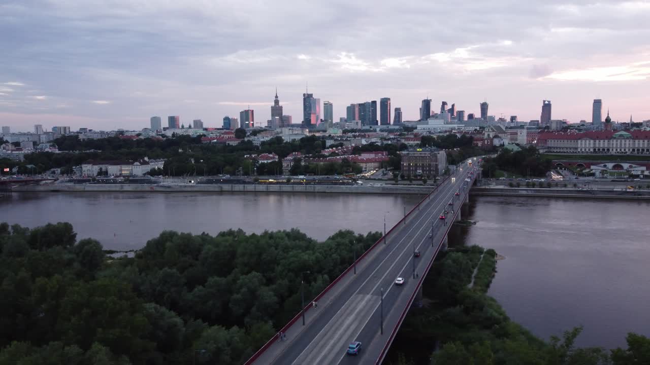 Filmagem cinematográfica de drone do horizonte de Varsóvia com o rio Vístula e ponte com tráfego intenso, paralaxe à esquerda com nuvens